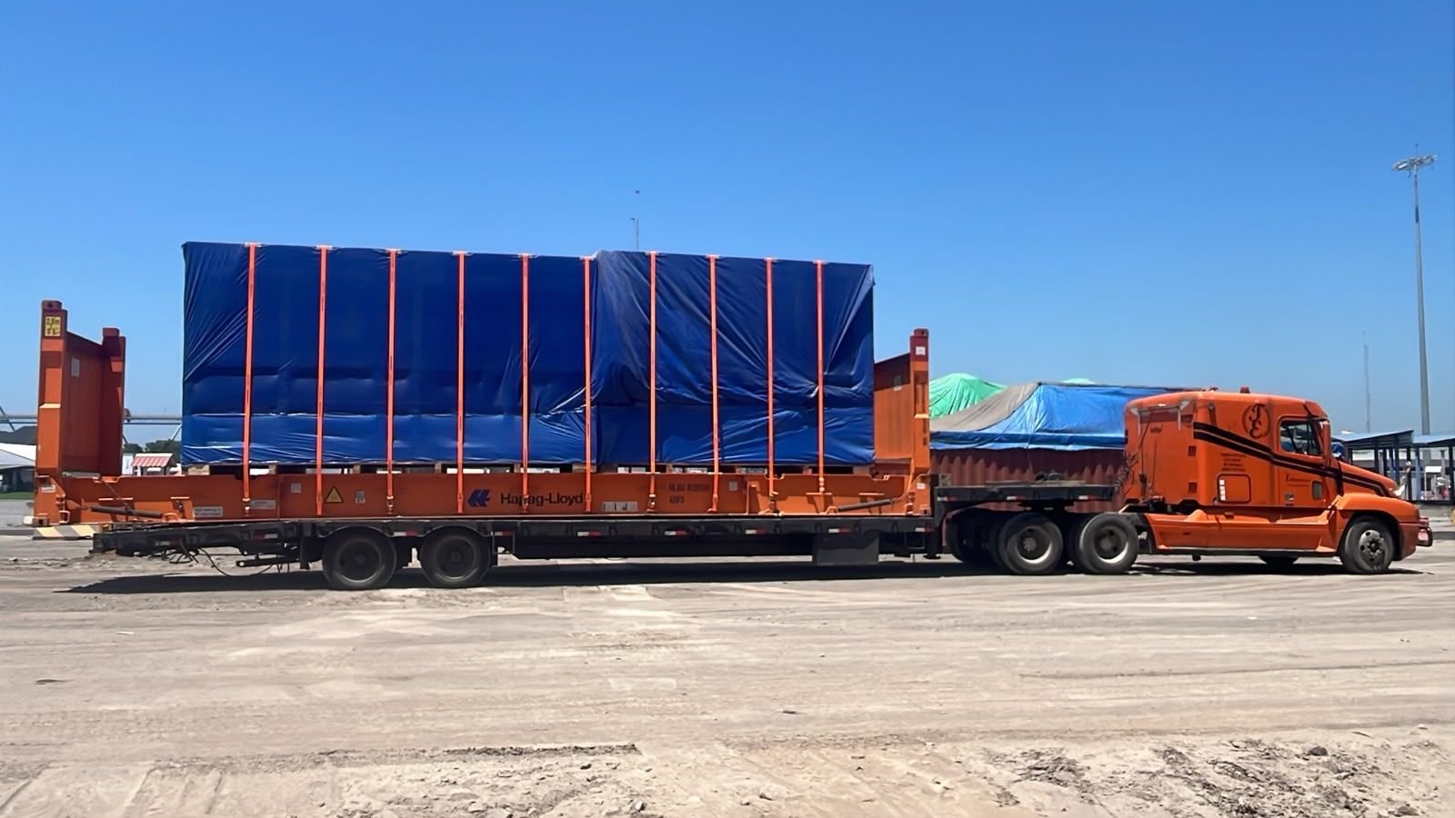 Cabezal con flat rack cargado y asegurado con eslingas en el puerto